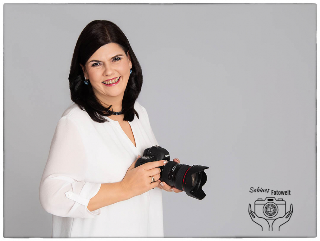 Sabine Friedrich Fotografin für Babybauch und Neugeborene hält Kamera in Händen